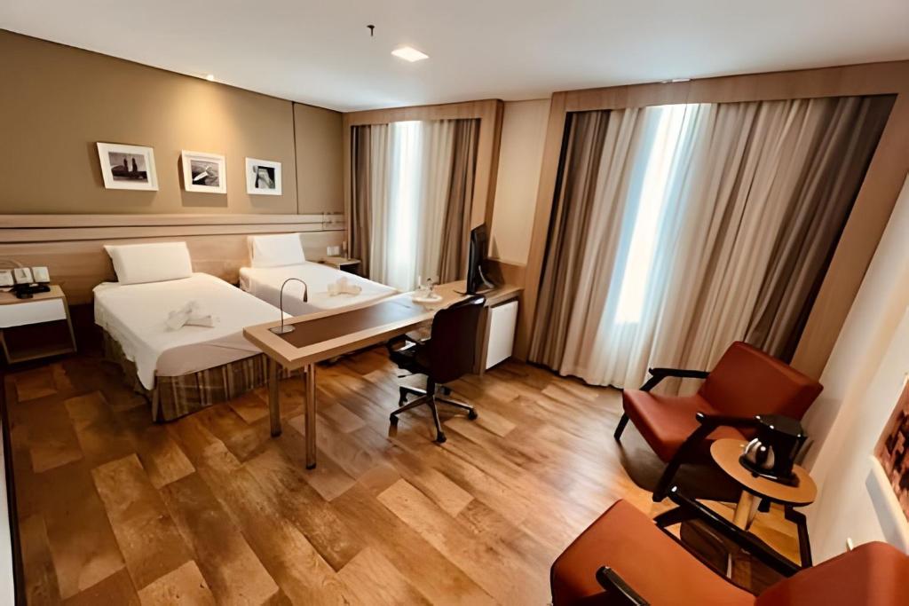 een hotelkamer met een bed en een bureau bij Apto Executivo no Intercity in Manaus