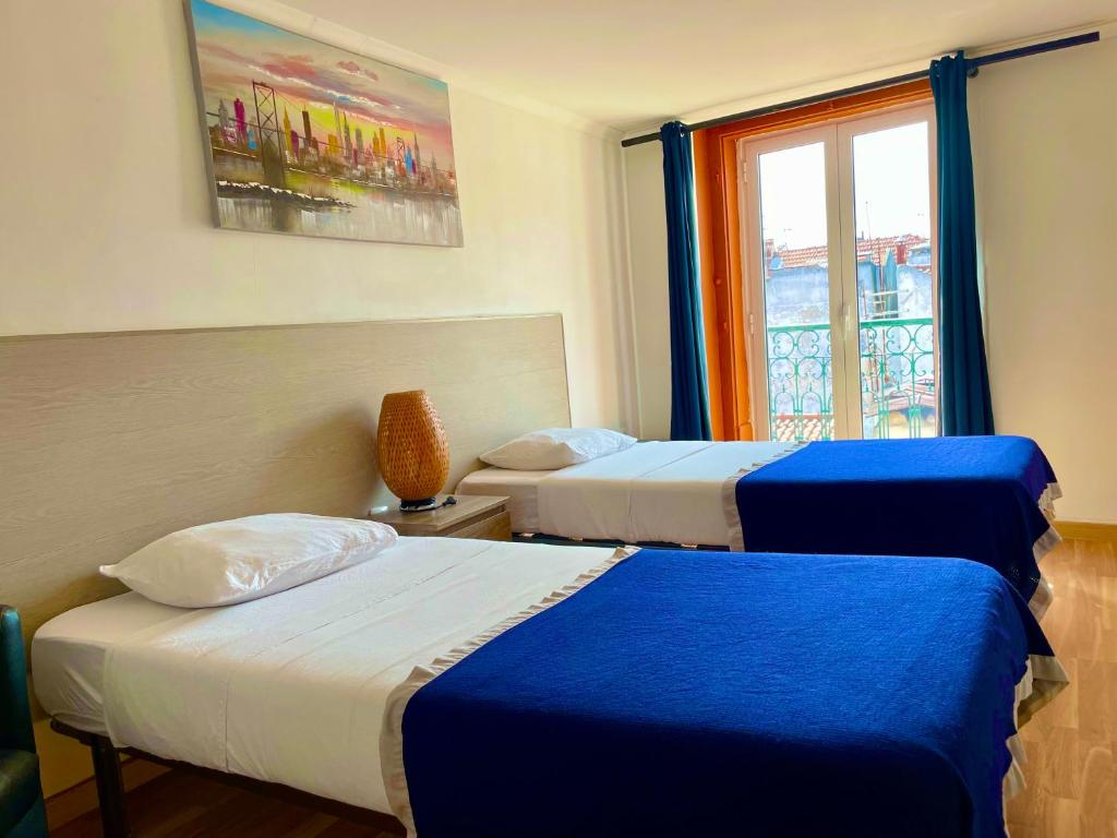 una camera d'albergo con due letti e una finestra di Lisbonaccommodation a Lisbona