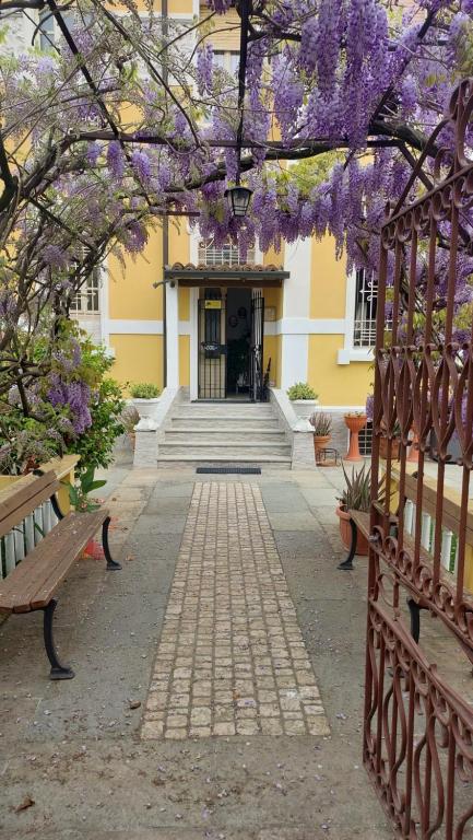 a building with purple flowers on a tree with benches at Villa Lina in Cremona