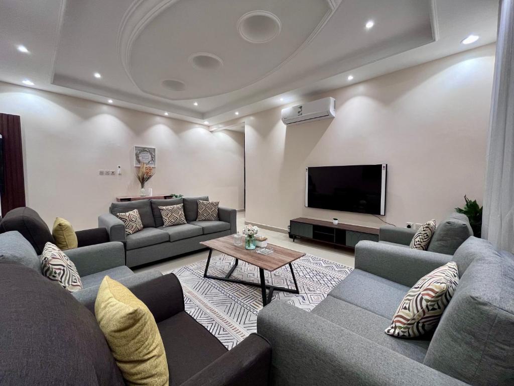 a living room with couches and a flat screen tv at شقق نسج المسكن دخول ذاتي شمال الرياض in Riyadh