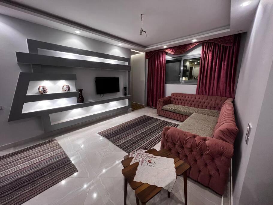 een woonkamer met een bank en een tv bij Luxury apartments in Heliopolis in Caïro