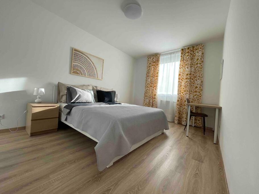 a bedroom with a large bed and a table at Magnolia in Trnávka