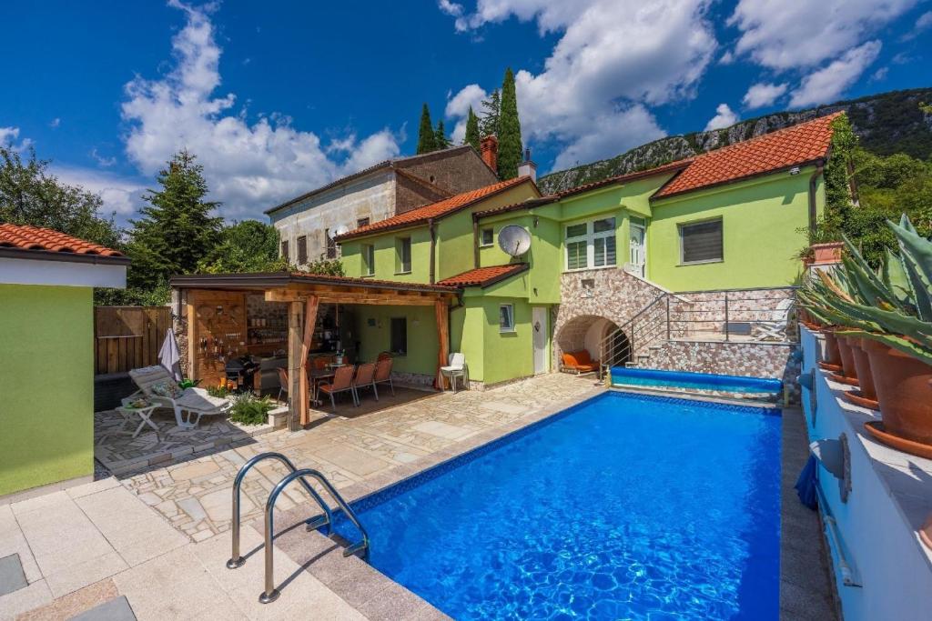 uma piscina em frente a uma casa em Ferienhaus mit zwei Küchen, Garten, großer Terrasse und Swimmingpool em Bribir