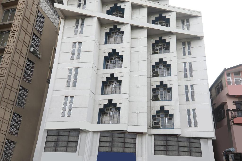 a white building with windows on the side of it at Super Collection O Hotel President in Guwahati