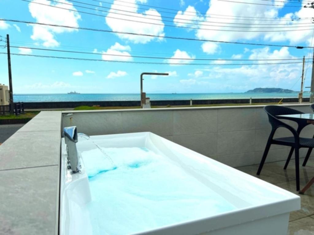 uma banheira com água azul na varanda em OCEAN FRONT TATEYAMA - Vacation STAY 37303v em Tateyama