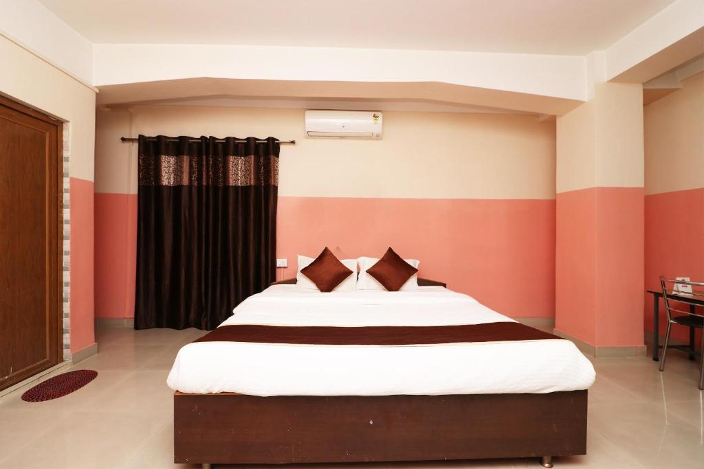 a bedroom with a bed with red and orange stripes at Prabha Palace Lodge in Kamakhya
