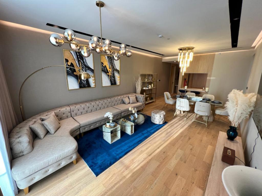 un soggiorno con un grande divano e un tappeto blu di Enjoy Luxury Condo with Sea View a Abu Dhabi
