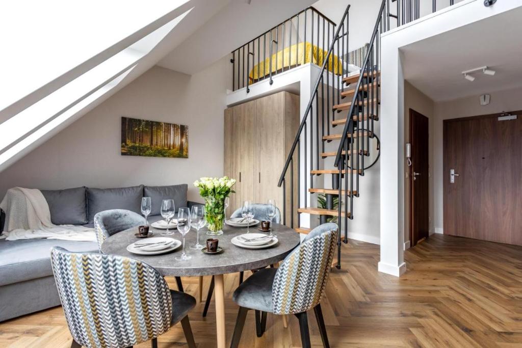 uma sala de jantar com uma mesa e cadeiras e uma escadaria em Apartament B28 Green Resort dwupoziomowy z Basenem, Sauną, Jacuzzi - 5D Apartments em Szklarska Poręba
