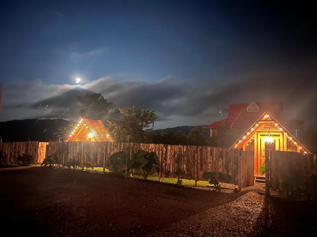 a house lit up at night with a fence at Ecolodge Los Pinos in Calima