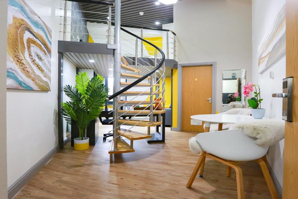 ein Büro mit einer Wendeltreppe sowie einem Tisch und Stühlen in der Unterkunft E104 Urban loft gem in Coventry