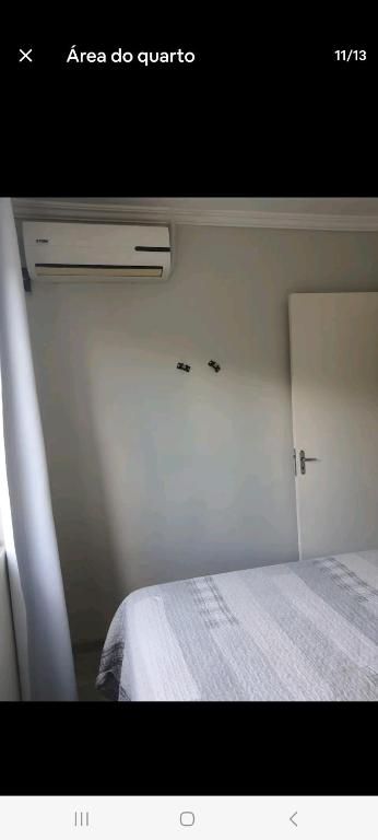 a bedroom with a white bed and a window at Apto Sirius 31 in Cascavel