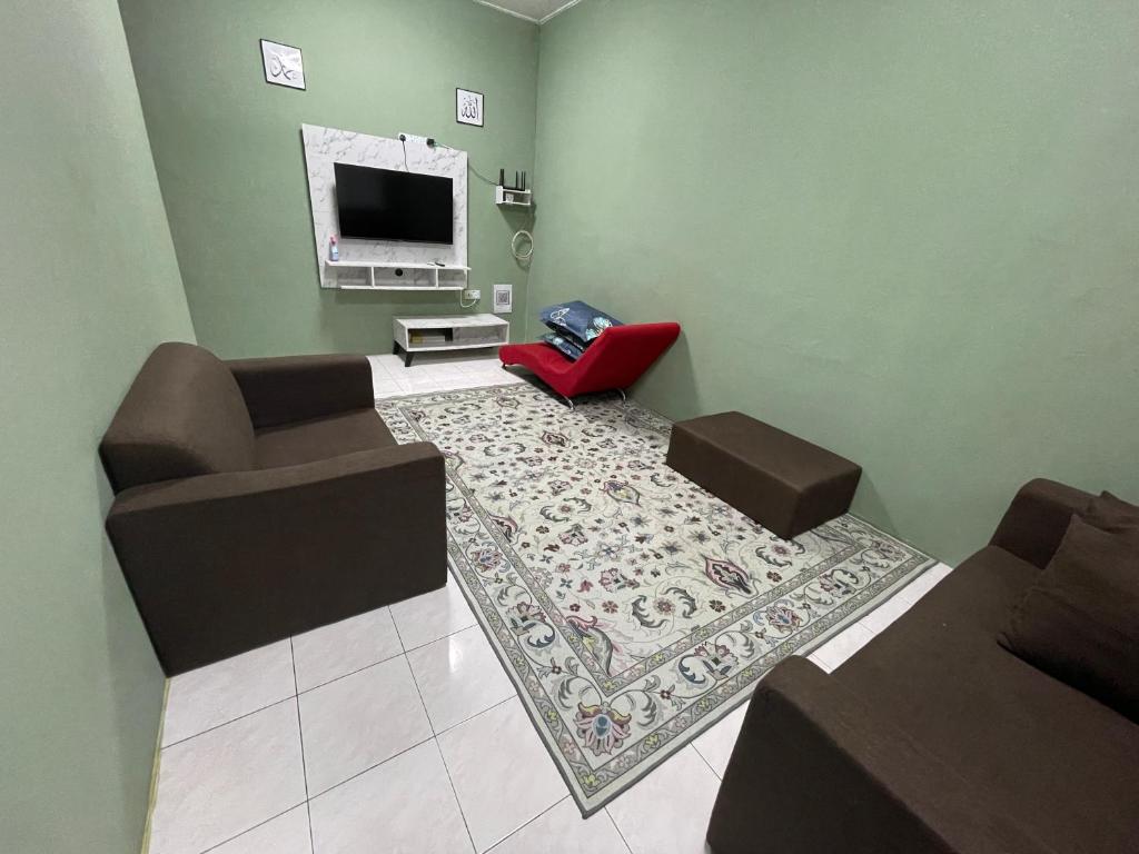 sala de estar con sofá y TV en Salam homestay en Kepala Batas