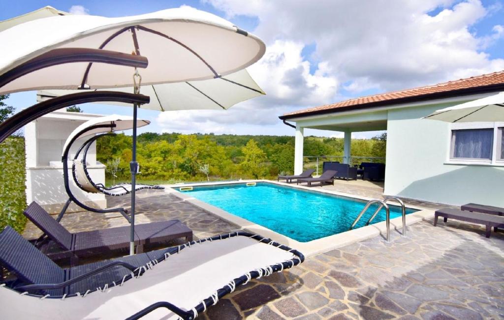 einen Pool mit Sonnenschirm neben einem Haus in der Unterkunft Großes Ferienhaus in Buroli mit Privatem Pool in Buroli