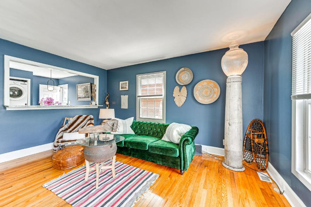 a living room with a green couch and blue walls at Eclectic Winston-Salem Home 3 Mi to Downtown! in Winston-Salem