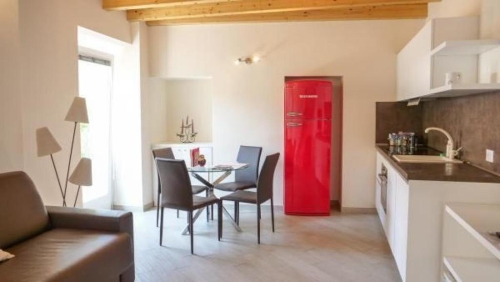 - un réfrigérateur rouge dans la cuisine avec une table et des chaises dans l'établissement Wohnung in Toscolano Maderno mit Garten, Grill und Terrasse, à Toscolano Maderno