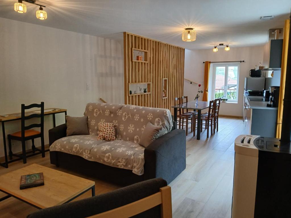 a living room with a couch and a table at Gite du Vieux Tonneau in Cerdon