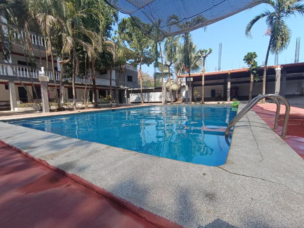 une piscine dans un hôtel avec des palmiers dans l'établissement 23 Villa del Mar, à La Libertad