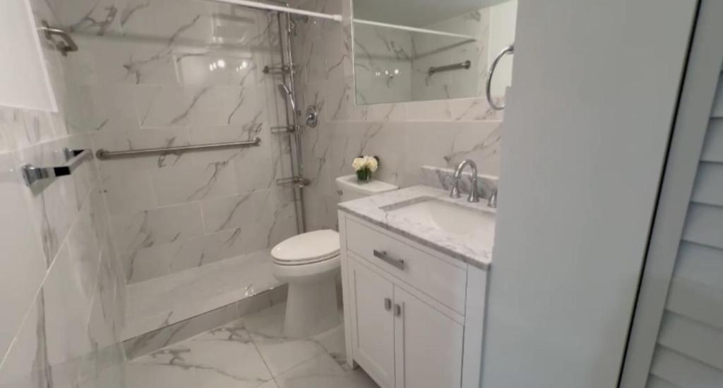 y baño con aseo, ducha y lavamanos. en Unique North Miami Bedrooms, en Miami