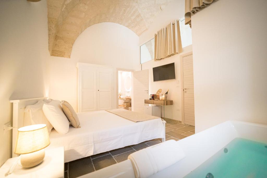 Schlafzimmer mit einem Bett und einer Badewanne in der Unterkunft Guerrieri Suites & Spa in Campi Salentina