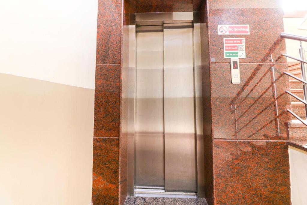 a stainless steel elevator in a building at Champion Comfort Near Hosahalli Metro Station in Bangalore