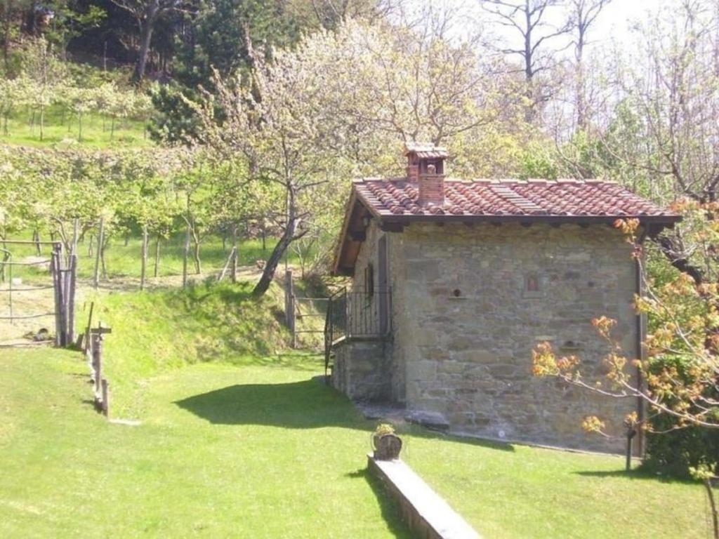 a small stone building in a field of grass at Appartement in Bibbiena mit Grill, gemeinsamem Pool und Garten in Bibbiena