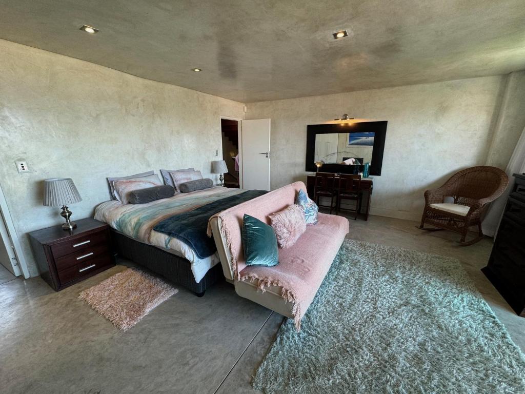 - une chambre avec un lit, un canapé et un miroir dans l'établissement Cozy family beachfront house., à Langstrand