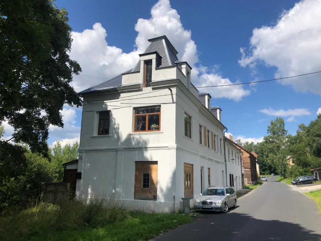 a white house with a car parked on the street at Blauer Stern Weipert in Chomutov