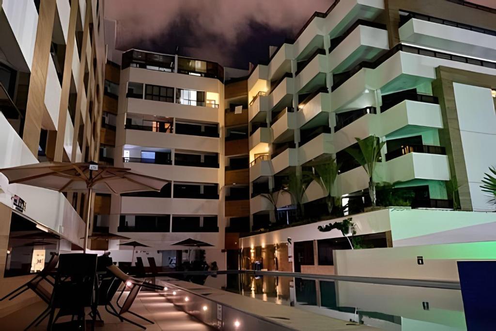 um edifício de apartamentos à noite com uma piscina em Aptos super confortáveis no Gold Flat by Apartamentos Jampa em João Pessoa