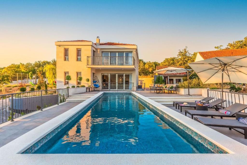 uma piscina em frente a uma casa em Ferienhaus in Dugopolje mit Privatem Pool em Dugopolje