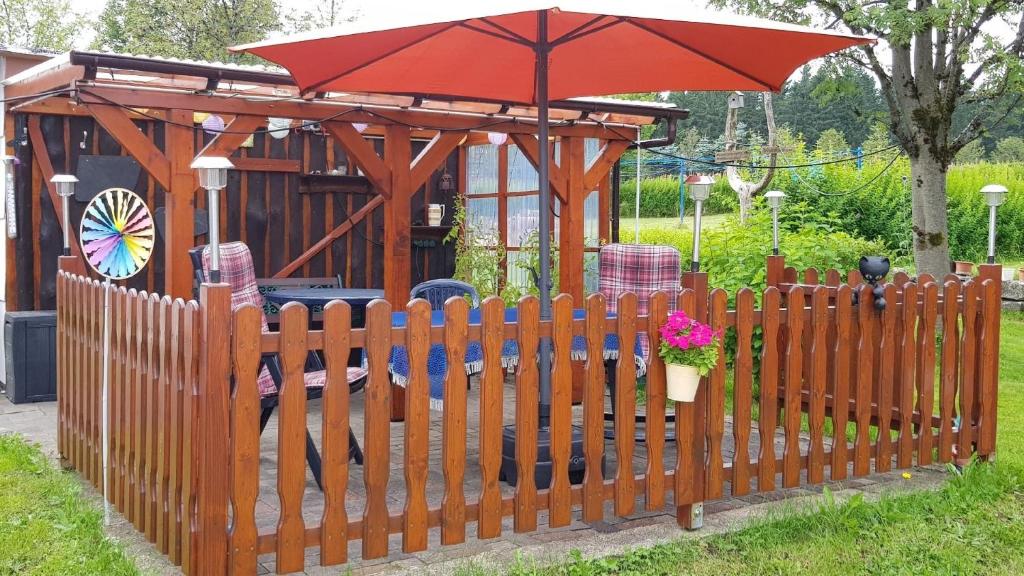 a wooden fence with an umbrella in a gazebo at Ferienzimmer im Thüringer Wald nahe dem Rennsteig in Siegmundsburg