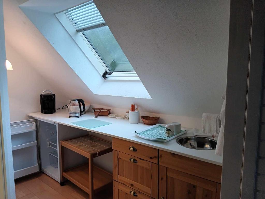 a kitchen with a sink and a skylight at Pension Eltmann in Eltmann