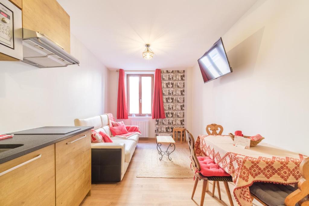 une cuisine et un salon avec une table et un canapé dans l'établissement Le Cœur de Theinheim, à Colmar