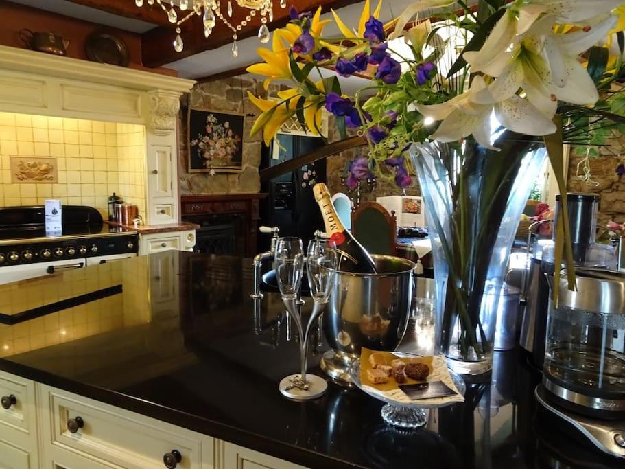a kitchen with a counter with a vase of flowers at WestLaigh Lrg Luxury Country Farm House 20 min from the city in Glassford
