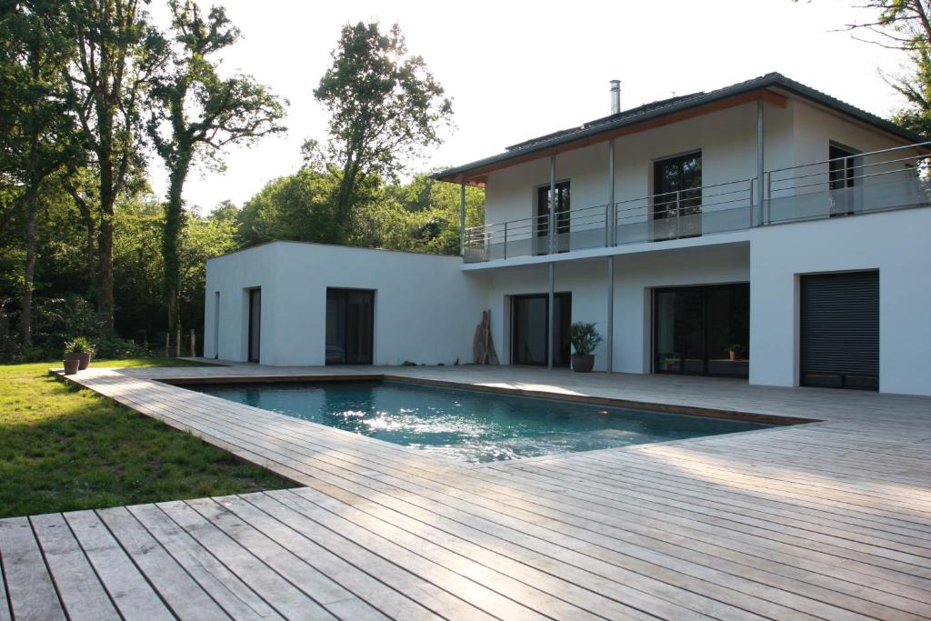 una casa con piscina frente a una casa en Lazuli Lodge, en Azur
