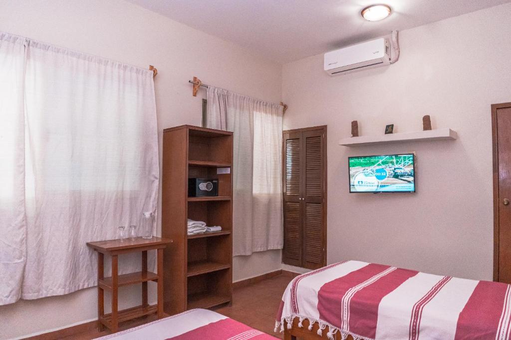 a bedroom with a bed and a tv on the wall at Hotel Don Nino in Oaxaca City