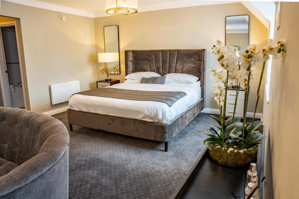 een slaapkamer met een groot bed en een bank bij The Pear Tree Inn & Country Hotel in Worcester