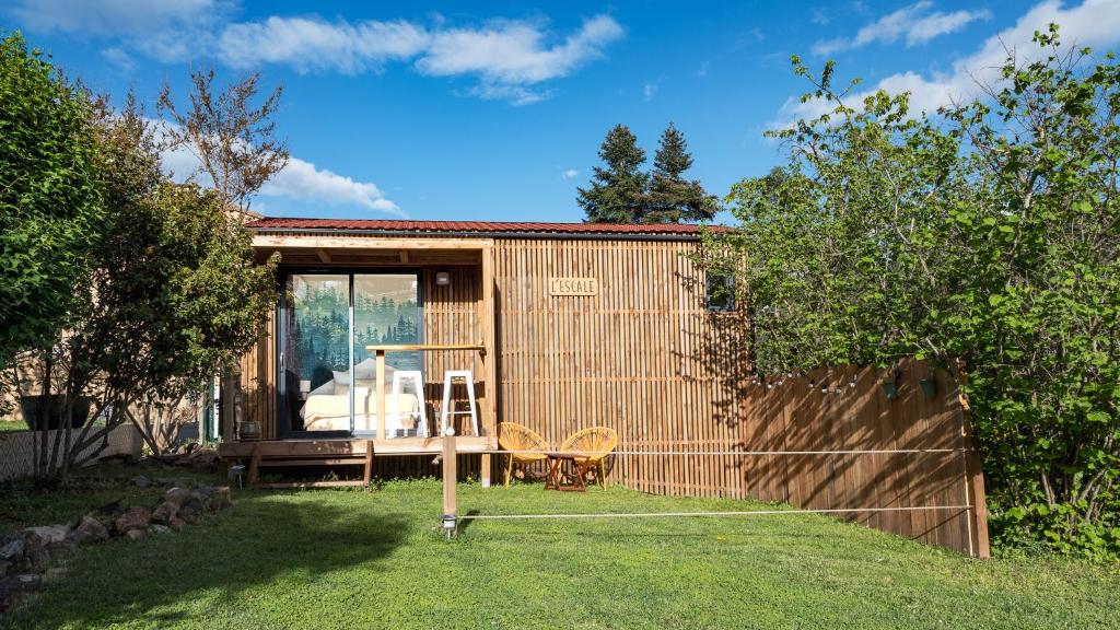 un pequeño cobertizo con una mesa y sillas en un patio en L'Escale - Les Lodges de Praly, en Les Ollières-sur-Eyrieux