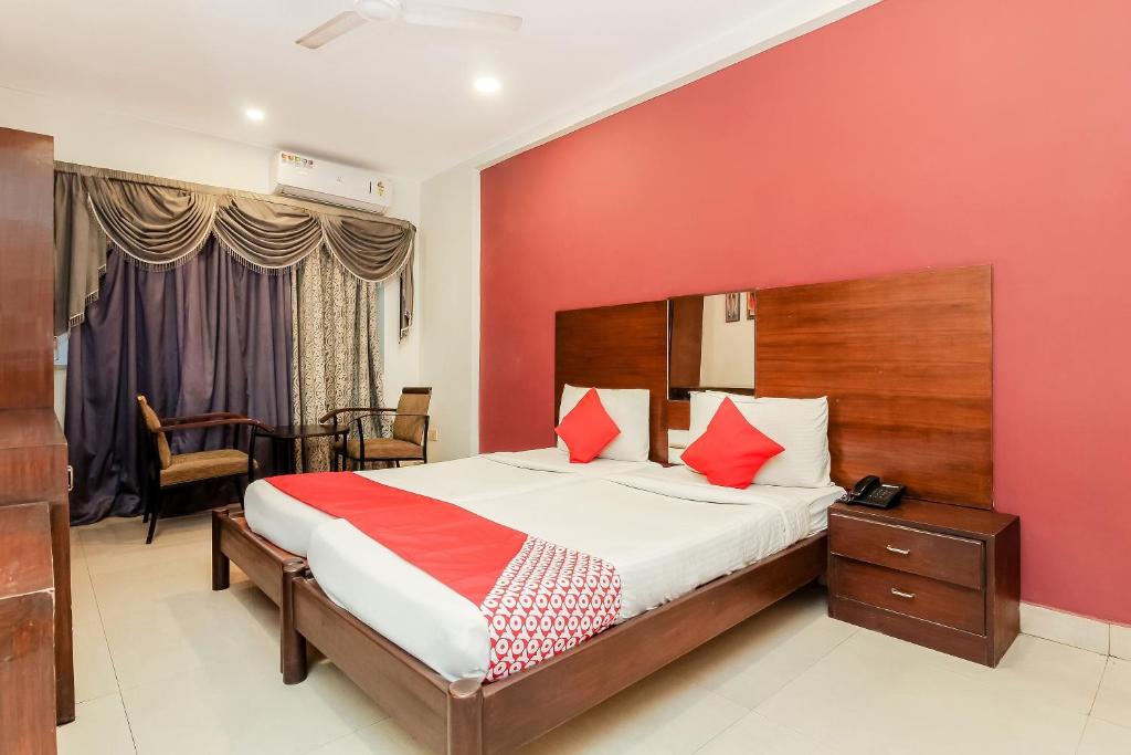 Ameerpet的住宿－Collection O Hotel Happy Stay Near Hyderabad Central，一间卧室设有一张床和红色的墙壁
