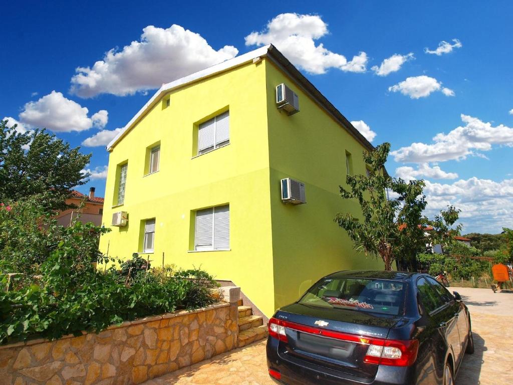 a yellow and green house with a car parked in front at Ferienwohnung für 3 Personen ca 36 qm in Pula-Fondole, Istrien Istrische Riviera in Pula