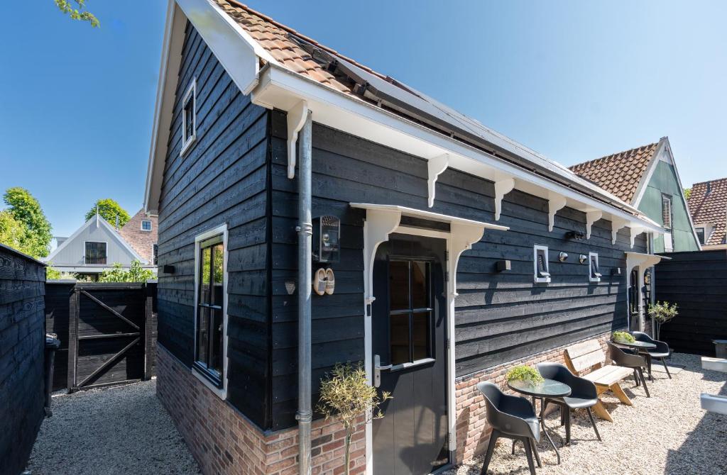ein Haus mit schwarzen Nebengleisen und einer Terrasse in der Unterkunft Luxury Chalets Monnickendam in Monnickendam
