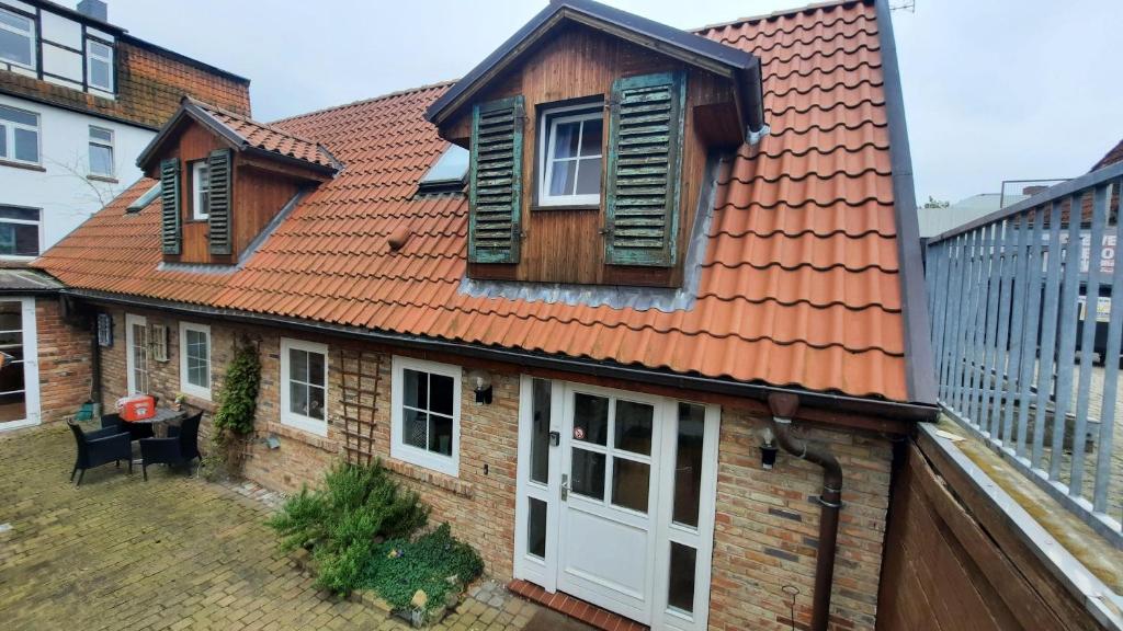 uma casa com um telhado laranja e uma porta branca em Hexenhaus em Lüneburg