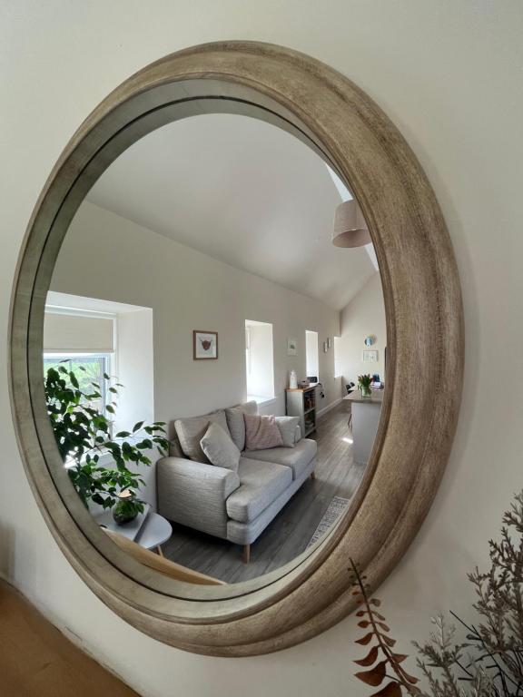 a living room with a large mirror on the wall at Tumbledown Croft, rural cottage near Cruden Bay in Peterhead