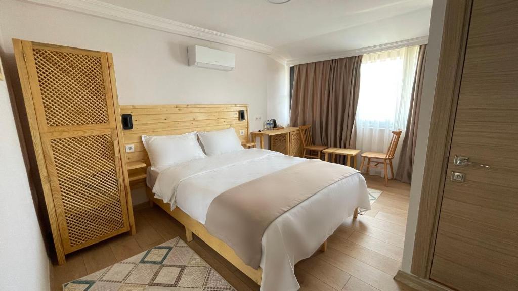 um quarto de hotel com uma cama grande e uma janela em Dalaman Airport AliBaba House em Dalaman