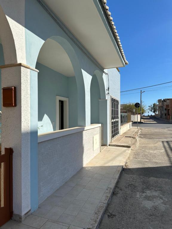 a building with arches on the side of a street at La dolce casa di Sara e Alessia in San Pietro in Bevagna