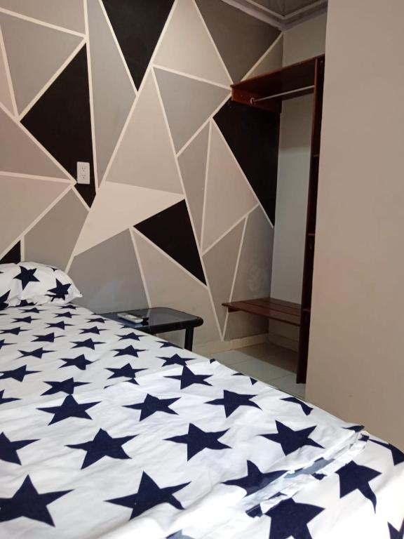 una camera da letto con un letto con stelle blu sopra di Hotel Candilejas Serenity a Barrancabermeja