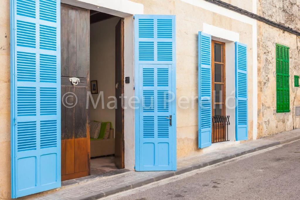 une porte ouverte avec volets bleus sur un bâtiment dans l'établissement Ferienhaus in Santa Margalida mit Kleinem Pool, à Santa Margalida