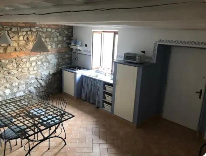uma cozinha com um balcão e uma mesa e uma mesa e uma mesa em Ca’ d’Irene em Bagnone