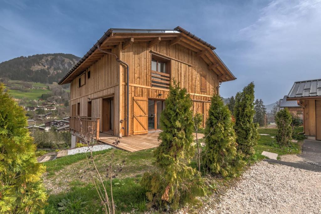 a wooden house on a hill with trees at Magnificent chalet with view in Praz-sur-Arly - Welkeys in Praz-sur-Arly