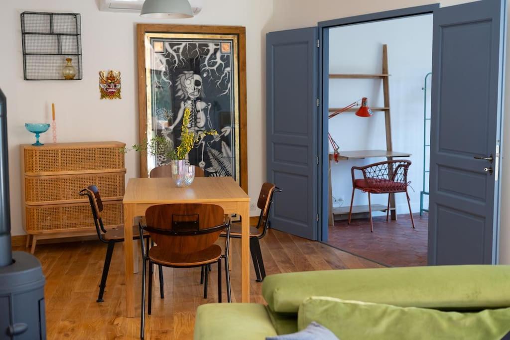 ein Wohnzimmer mit blauen Türen und einem Tisch in der Unterkunft Appartement T3 bas de Villa in Vero