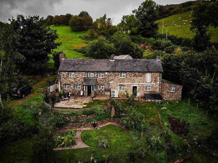 an old stone house on a grassy hill at Family time in the Welsh hills! in Llanfyllin